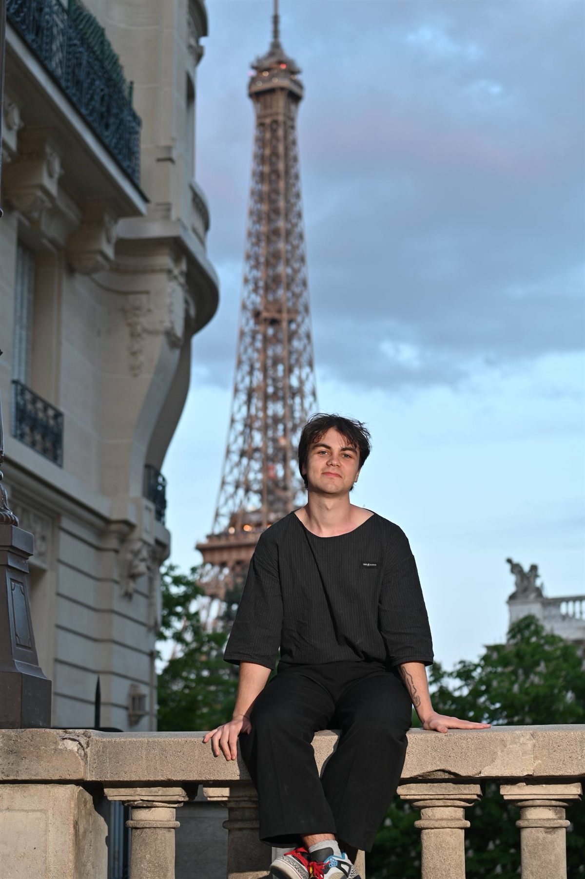 Mark sitting in front of the Eiffel Tower